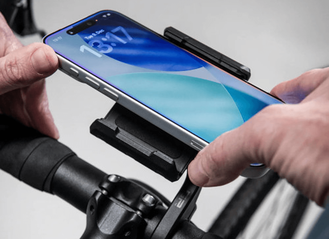 A phone clicking into an SP Connect mount on a set of handlebars